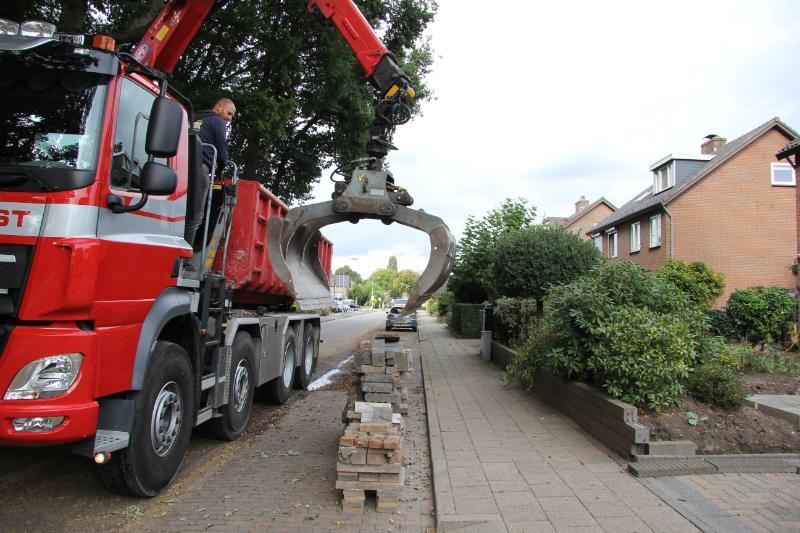 Tegeltaxi haalt met grijper een stapel tegels op in de gemeente Oldebroek