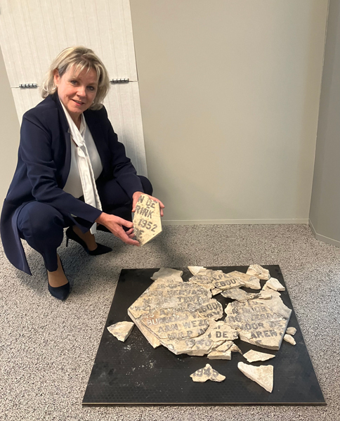 Burgemeester Tanja Haseloop–Amsing toont een van de brokstukken van de gedenksteen